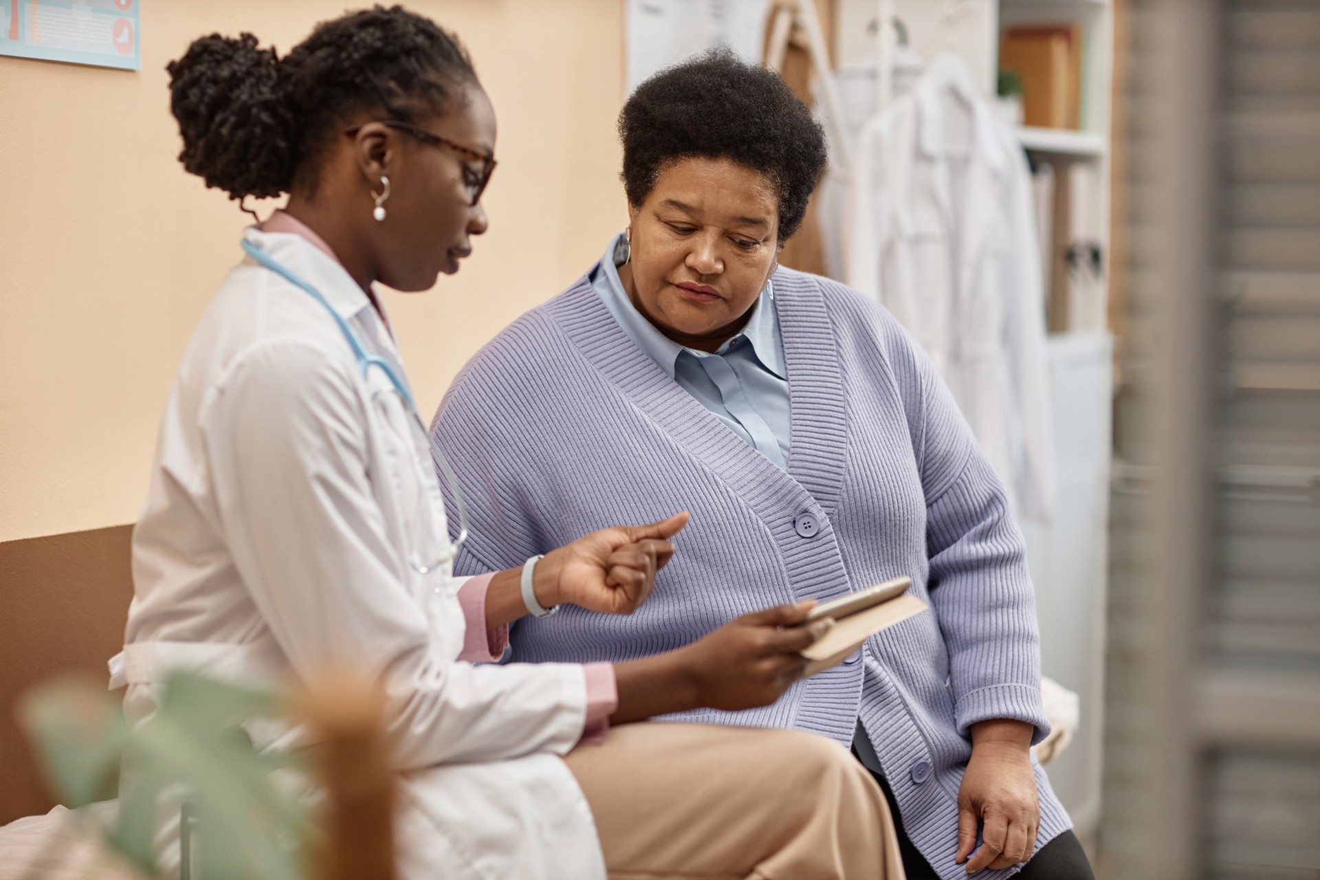 Female Patient Listening to Doctor Holding Tablet